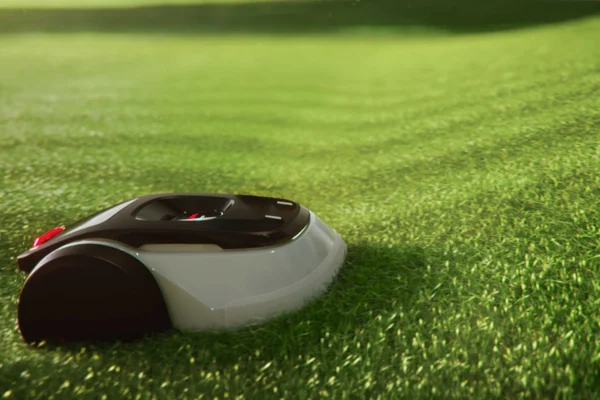 Low side view of robotic mower moving through thick green grass.